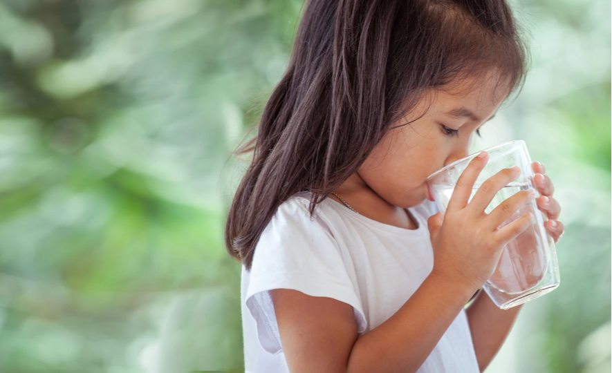 Young girl drinking a glass of water